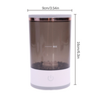 Cylindrical makeup brush cleaner with a translucent grey body, white base, and power button, measuring 9x16cm.