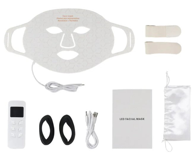 White silicone LED face mask with geometric pattern, remote control, straps, cable, manual, and storage pouch.