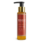 A tall, clear amber bottle of body oil with a gold and black pump dispenser and a red label.