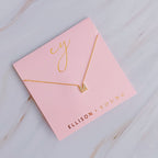 Gold initial pendant necklace on pink card with "ELLISON + YOUNG" and "ey" in gold lettering.